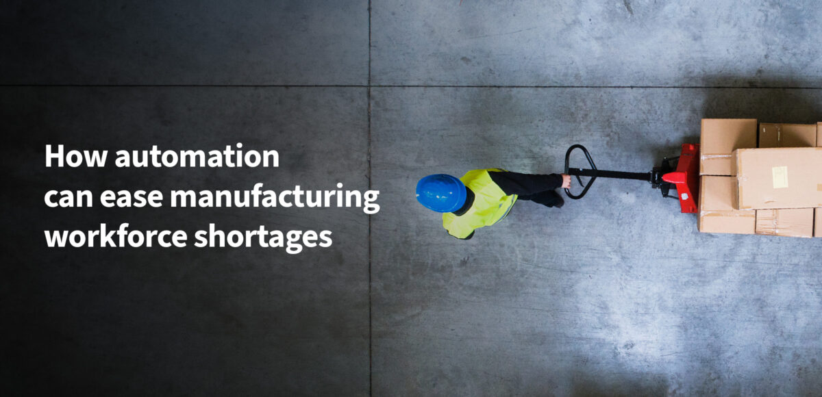 Worker moving boxes with a pallet truck, illustrating how automation can ease manufacturing workforce shortages.